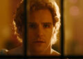 A college student looking through a door in True Haunting.