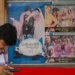 A moviegoer checks his phone whilst standing beside a poster of the popular Bollywood Hindi film 'Dilwale Dulhania Le Jayenge' in Mumbai