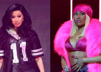 Cardi B in a sparkly jersey and Nicki Minaj in a pink outfit, both performing on stage.