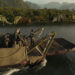 The team on the boat looking at various dinosaurs on the shore in Primitive War
