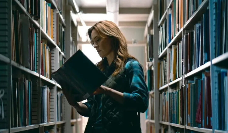 Mia Brennan amidst library stacks in Shelby Oaks