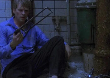 Lawrence holding a saw in Saw