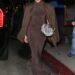 Jennifer Lopez wears a brown dress and matching jacket, carries a furry clutch, and wears peep-toe platforms