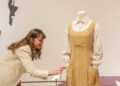 Elyse Gerstenecker, curator of decorative Arts, carefully pushes in a pin that is sticking out without touching the costume during the Art of the Character exhibit, featuring highlights from Glenn Close's costume collection on Thursday, October 9, 2025 at the Jepson Center for the Arts.