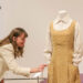 Elyse Gerstenecker, curator of decorative Arts, carefully pushes in a pin that is sticking out without touching the costume during the Art of the Character exhibit, featuring highlights from Glenn Close's costume collection on Thursday, October 9, 2025 at the Jepson Center for the Arts.