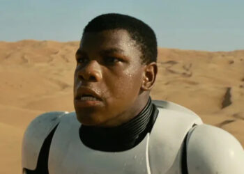 John Boyega as Finn wearing a Stormtrooper armor in the desert in Star Wars: The Force Awakens
