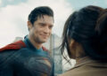 David Corenswet as Superman in Superman, dirty but smiling at a woman he just saved