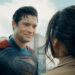 David Corenswet as Superman in Superman, dirty but smiling at a woman he just saved