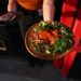 A server presents the Sabana de Atún dish at Malinche Audiobar in downtown Denver., on Oct. 16, 2025. (Photo by RJ Sangosti/The Denver Post)