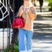 Katie Holmes carrying her Metier red bag and wearing wide-leg jeans and Autry sneakers