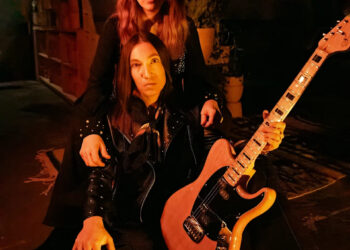Katy Guillen & The Drive. Katy Guillen is holding the guitar in the photo.