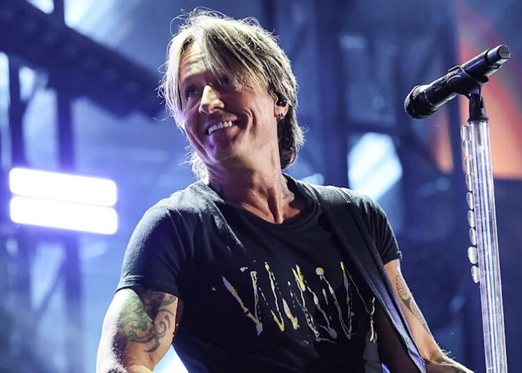 Keith Urban wearing a black shirt while on stage at CMA Fest in June 2025.