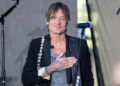 keith urban on stage with his hand over his heart