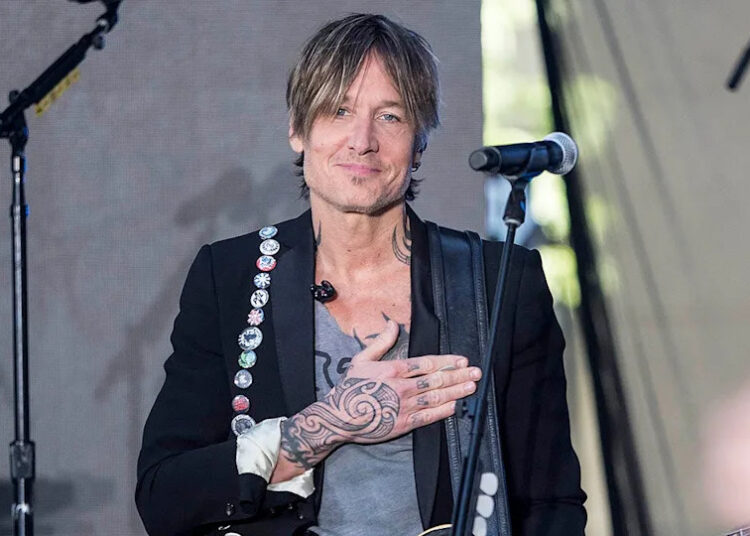 keith urban on stage with his hand over his heart