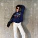 Kendall Jenner wears a track jacket, white pants, and black loafers