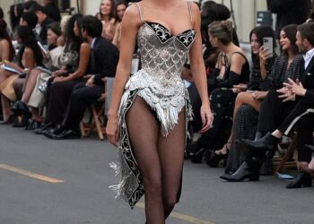 Jenner donned the sparkling silver, corset bodysuit with tasseled details and fabric that fell down behind her