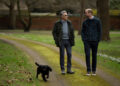 Prince William walking in a park with Eugene Levy and Orla the dog