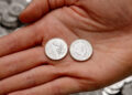 The first 5p coin with King Charles III on it shown next to the oak leaf design on its other side