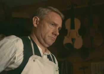 Martin Freeman's Malcolm ties his apron as he looks into the distance in Queen of Bones