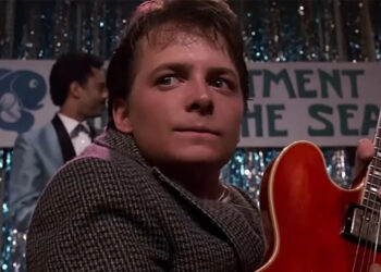 A close up of Michael J. Fox holding the red guitar in Back to the Future.