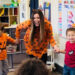 Children in halloween clothes dancing with an instructor.