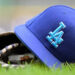 A Los Angeles Dodgers hat sits on a a baseball glove during a MLB game between the Milwaukee Brewers and Los Angeles Dodgers on August 12, 2024, at American Family Field in Milwaukee, WI.