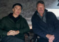 Cillian Murphy as Thomas Shelby sitting next to creator Steven Knight in a behind-the-scenes picture for Peaky Blinders
