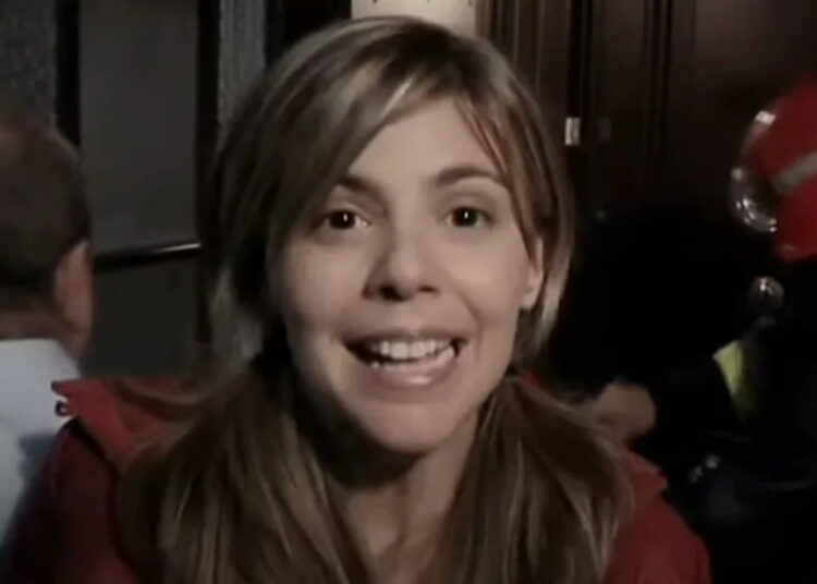 Ángela speaking to camera in hallway in [REC].