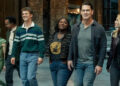 Nhut Le as Judomaster, Tim Meadows as Langston Fleury, Freddie Stroma as Vigilante, Danielle Brooks as Leota Adebayo, John Cena as Peacemaker, and Jennifer Holland as Emilia Harcourt walking in their new office together on Peacemaker
