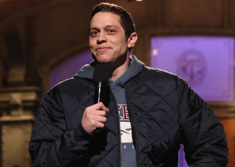 Pete Davidson holding a mic on SNL