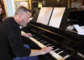 Musician Mark Edwards is seated, playing the same piano used by Duke Ellington in Eastbourne in 1973.