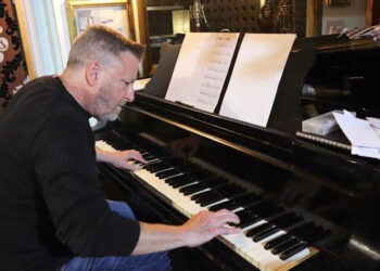 Musician Mark Edwards is seated, playing the same piano used by Duke Ellington in Eastbourne in 1973.