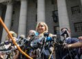 Virginia Roberts Giuffre, center, who says she was trafficked by sex offender Jeffrey Epstein, holds a news conference outside a Manhattan court where sexual assault claimants invited by a judge addressed a hearing following Epstein's jailhouse death in New York, Aug. 27, 2019. (AP Photo/Bebeto Matthews, File)