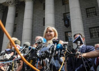 Virginia Roberts Giuffre, center, who says she was trafficked by sex offender Jeffrey Epstein, holds a news conference outside a Manhattan court where sexual assault claimants invited by a judge addressed a hearing following Epstein's jailhouse death in New York, Aug. 27, 2019. (AP Photo/Bebeto Matthews, File)
