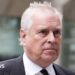A headshot of Prince Andrew who looks to the right of the camera. The background is blurred