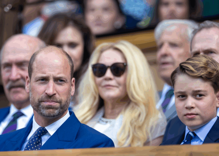 Prince George and Prince William sitting in the stands wearing blue suits at Wimbledon
