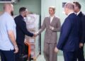 Princess Charlene wearing a baggy suit shaking hands with a man