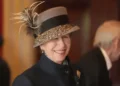 PA Media The Princess Royal wearing a black coat and grey hat with a feather. She is smiling.