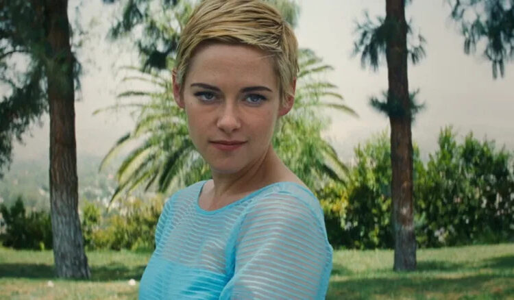 Kristen Stewart's Jean Seberg is seen in closeup with palm trees in the background in Seberg
