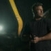 alt="Reacher holds a gun and looks to his side in Reacher season 3"