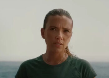 Scarlett Johansson looking skeptically at someone off screen in Jurassic World Rebirth near a large body of water.