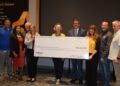 people standing with giant check