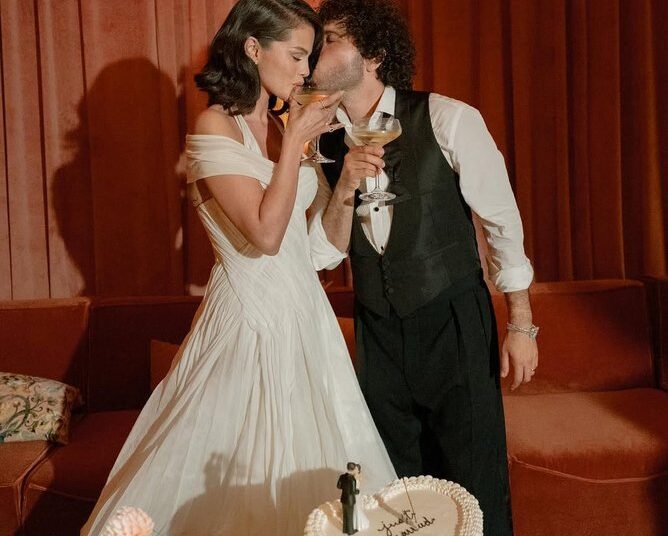 The celebration, held under a floral arch inside a white-draped tent, featured autumnal colors and dahlia arrangements throughout the candle-lit tables, along with velvet rust-colored lounge seating.