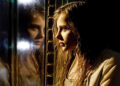 Abby stares through her reflection in Let Me In