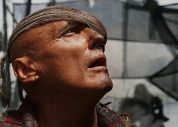 Dennis Hopper as Deacon staring up in disbelief in Waterworld
