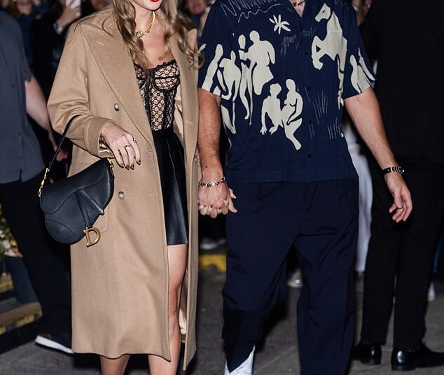 Taylor Swift released her raunchiest song yet with her track Wood from her new album The Life of a Showgirl; pictured with fiancé Travis Kelce in October 2024
