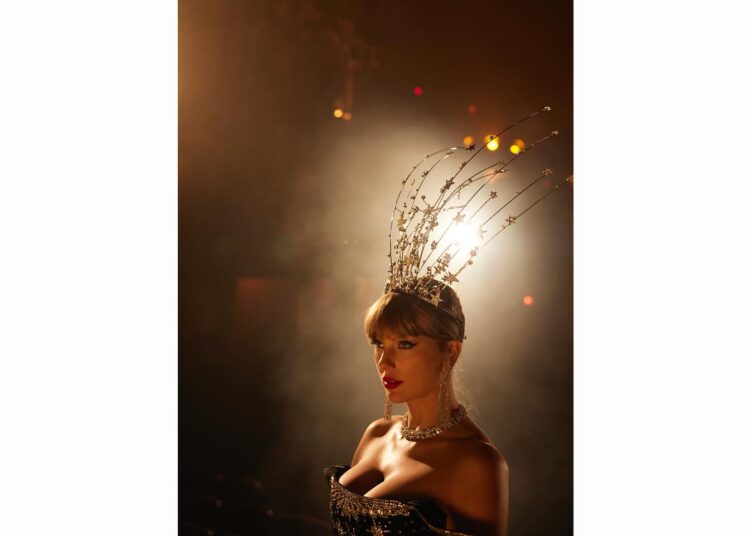 Taylor Swift on a stage wearing a star headdress and an Annie's Ibiza dress