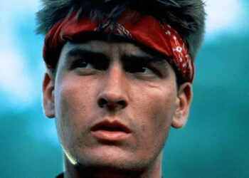 Chris Taylor wearing a red headband in the jungle in Platoon