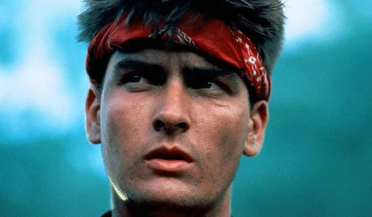Chris Taylor wearing a red headband in the jungle in Platoon