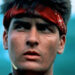 Chris Taylor wearing a red headband in the jungle in Platoon